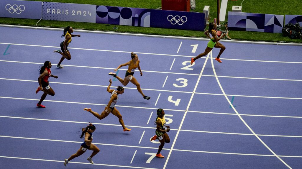 Paris 2024 Olimpiyatları'nda Stade de France'ın mor pistinde kadın sprinterler bitiş çizgisine koşuyor